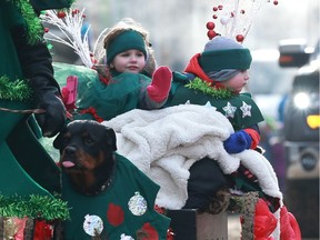 Children are pulled by a dog-drawn wagon during the Santa Claus Parade downtown Saskatoon on November 19, 2017.