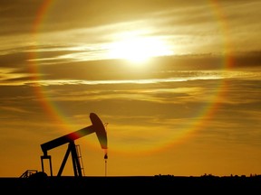 An oil well pumps against the setting sun.