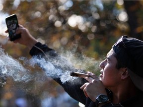 A man takes a selfie as he smokes a marijuana cigarette during a legalization party at Trinity Bellwoods Park in Toronto, Ontario, October 17, 2018. - Nearly a century of marijuana prohibition came to an end Wednesday as Canada became the first major Western nation to legalize and regulate its sale and recreational use. Scores of customers braved the cold for hours outside Tweed, a pot boutique in St John's, Newfoundland that opened briefly at midnight, to buy their first grams of legal cannabis.In total, Statistics Canada says 5.4 million Canadians will buy cannabis from legal dispensaries in 2018 -- about 15 percent of the population. Around 4.9 million already smoke.