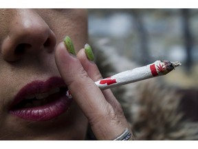 Krissy Calkins smokes a marijuana joint at a "Wake and Bake" legalized marijuana event in Toronto on Wednesday, October 17, 2018. The cannabis product shortages that have plagued many provinces in Canada will likely persist for years, industry insiders say.