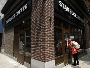 In this May 29, 2018, file photo a woman peers into a closed Starbucks Coffee shop in Philadelphia. Starbucks Corp. reports earnings Thursday, Nov. 1.