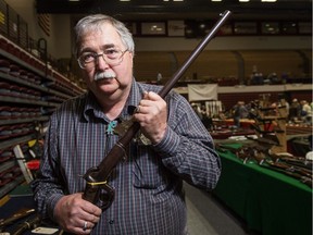 Hayes Otoupalik, an organizer of the 63rd annual Missoula Gun Show, stands on the show's main vendor floor in a gymnasium at the University of Montana. He is pictured holding a .54 calibre, civil war era Burnside carbine he just purchased from a vendor.