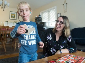 Melanie Hack, right, and her three-year-old son Gideon Hack, play with a puzzle on the coffee table in their front room. Gideon has hearing loss due to Sotos syndrome.