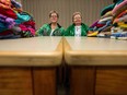 Evelyn Sundet, right, and her daughter Terri Leniuk sit in the common area in the home where Sundet resides. Each sits beside a collection of garments they've made for donation.