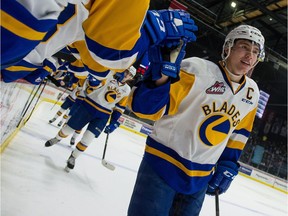 The Saskatoon Blades' captain Kirby Dach (77) high-fives team members after his team scored against the Regina Pats during a game at the Brandt Centre on Nov. 3, 2018.