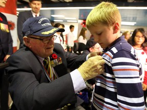 Korean War Veteran Richard Ratcliffe pins a poppy on Daniel Bondar,11, during the launch of the Toronto Royal Canadian Legion's annual TTC Poppy Campaign at North York Centre Station in Toronto on Friday October 26, 2018. (Dave Abel/Toronto Sun/Postmedia Network)