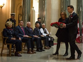 Nathan Markwart, right, and Nancy Seman carry a wreath during the annual Service of Remembrance in the rotunda at the Saskatchewan Legislative Building.