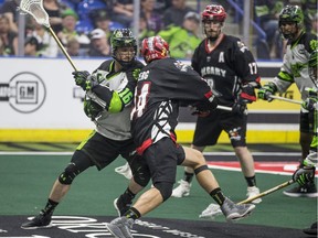 Saskatchewan Rush transition Chris Corbeil  (16) battles with Calgary Roughnecks forward Wesley Berg  (14) during second quarter action in Saskatoon, SK on Saturday, April 28, 2018.