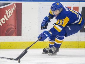 Saskatoon Blades forward Tristen Robins takes the puck away from Calgary Hitman defence Layne Toder during first period WHL action at SaskTel Centre in Saskatoon, SK on Wednesday, October 17, 2018.