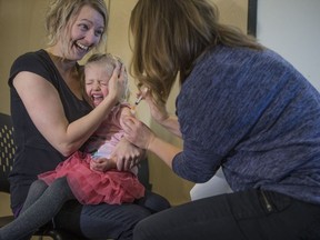 Sarah Skanderbeg holds her daughter Eve Skanderbeg as she receives a flu shot from Sarah Sokoluk during the flu clinic opening day at Station 20 West in Saskatoon, Sk on Monday, October 22, 2018.