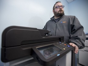 Darryl Arnold, owner of Kelly's Computer Works, stands for a photograph with a fax machine in North Battleford, SK on Tuesday, December 11, 2018. Arnold's store has had confidential patient information faxed to his fax machine by the health region.