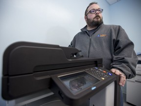 Darryl Arnold, co-owner of Kelly's Computer Works, alongside the fax machine in North Battleford to which confidential patient information has been sent by the Saskatchewan Health Region