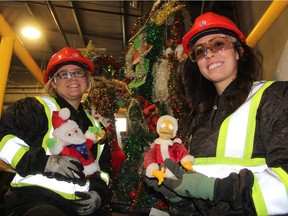 Kim Schmidt, left, a digital media specialist with Loraas Disposal Services Ltd., stands beside a Christmas Tree made of decorations that cannot be recycled, with Jenna Curson, an environmental communications specialist. The two starred in Loraas' "12 Days of Wishmas" campaign, which aims to educate members of the public on which items can be recycled throughout the holiday season.