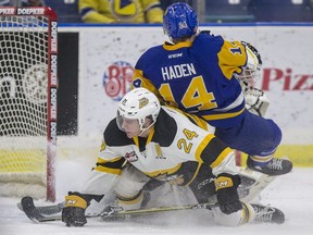 Saskatoon Blades forward Gary Haden gets knocked into Brandon Wheat Kings goalie Ethan Kruger by forward Connor Gutenberg during first-period WHL action at SaskTel Centre in Saskatoon on Friday, December 14, 2018. A goal by Kirby Dach was waved off by official as Haden was given a penalty for goaltender interference.
