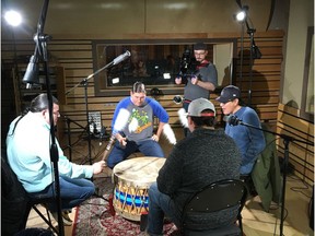 Don Speidel, Hunter Basingame, Darrell Paskimin, and Matthew Whitecloud play the drum at the RAIS recording studio in Saskatoon while working on Darryl Dozlaw's reconciliation song It Is Ours in November of 2018.