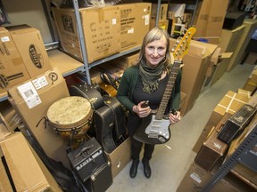 Eliza Doyle stands for a photograph with donations of instruments at the Long and McQuade on 8th Street in Saskatoon, SK on Wednesday, December 19, 2018. Doyle, a professional banjo player, travelled to Stanley Mission, SK, for the month of January working through the Saskatchewan Cultural Exchange to teach music to community members.