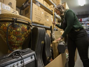 Eliza Doyle sorts donations of instruments at Long and McQuade on 8th Street in Saskatoon on Wednesday, December 19, 2018. Doyle, a professional banjo player, will be traveling to Stanley Mission, SK, for the month of January working thought the Saskatchewan Cultural Exchange to teach music to community members.
