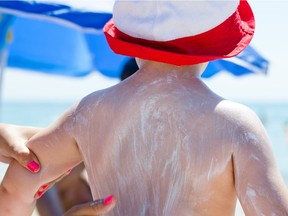 Mother applying sun screen lotion on her child.