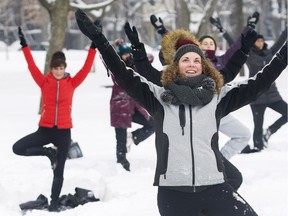 Melissa Ciampanelli, front, participates in an outdoor yoga session at a city park in Montreal, Saturday, February 10, 2018.