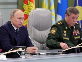 Russian President Vladimir Putin, left, and Chief of General Staff of Russia Valery Gerasimov oversee the test launch of the Avangard hypersonic glide vehicle from the Defense Ministry's control room in Moscow, Russia, Wednesday, Dec. 26, 2018. In the test, the Avangard was launched from the Dombarovskiy missile base in the southern Ural Mountains. The Kremlin says it successfully hit a designated practice target on the Kura shooting range on Kamchatka, 6,000 kilometers (3,700 miles) away.