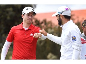 Nick Taylor (L) and Adam Hadwin (R) of Canada bump fists on the final day of the World Cup of Golf at the Metropolitan Golf Club in Melbourne on November 25, 2018.