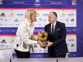 Lyon's Norwegian forward Ada Hegerberg (L) winner of 2018 Women's Ballon d'Or award for best player of the year, and Lyon's French President Jean-Michel Aulas pose with the trophy at the Groupama training center in Lyon, central eastern France, on December 4, 2018 during a press conference. - Awarded the Golden Ball on December 3, Hegerberg is the first woman who won the price.