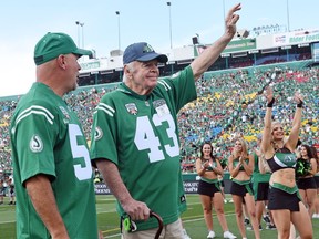 Ted Urness, shown with his son Mark, waves to the fans at Taylor Field in 2016.