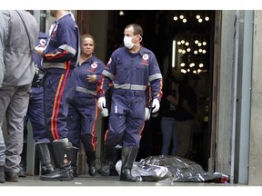 A firefighter walks next to a victim killed at the Metropolitan Cathedral in Campinas, Brazil, Tuesday, Dec.11, 2018. Authorities say an armed man entered the cathedral in southern Brazil on Tuesday afternoon and opened fire, killing at least four people before killing himself.