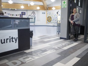 Martha Morin, wellness co-ordinator for the Dene High School, stands for a photograph by the school's main entrance where the words "Dene Strong" are displayed. The school was reopened on Jan. 18, 2019 following renovations that were necessitated following the 2016 school shooting.