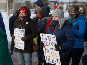 Jessica Fisher and Madi Kuhn stand with signs at the third annual Women's March at River Landing in Saskatoon raising awareness for ending violence against women on Jan. 19, 2019.