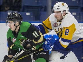 Prince Albert Raiders forward Spencer Moe batttles for the puck with Saskatoon Blades defenceman Seth Bafaro on Dec. 27, 2018