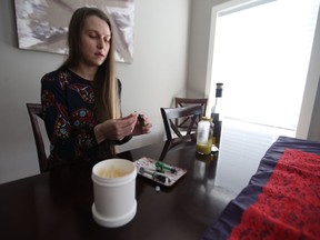 Alicia Yascheshen demonstrates how she prepares a medical cannabis pill in her apartment in Saskatoon on Jan. 18, 2018. Yascheshen is asking a Saskatchewan court to compel the provincial government to retroactively fund her medicinal cannabis.