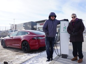 Electric vehicle owners and advocates Jason Cruickshank (left) and Pat Keyser stand next to their electric cars at the Preston Crossing charging station in Saskatoon, SK on Friday January 18, 2019. (Erin Petrow/ Saskatoon StarPhoenix)