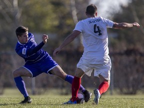 Saskatoon Revolution midfielder Tanner Stephens battles for the ball with Edmonton Scottish SC defender Mike Mccormick during the Challenge Trophy Toyota national club men's soccer championship at Umea Field 5 in Saskatoon, SK on Sunday, October 7, 2018.