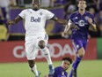 In this Saturday, Aug. 26, 2017, file photo, Vancouver Whitecaps's Alphonso Davies, left, leaps over Orlando City 's Cristian Higuita after the two collided going after the ball during the second half of an MLS soccer match in Orlando, Fla.