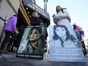 Brenda Jenkyns, left, and Catherine Van Tighem, who drove from Calgary, stand with signs outside of the premiere of the "Leaving Neverland" Michael Jackson documentary film at the Egyptian Theatre during the Sundance Film Festival, Friday, Jan. 25, 2019, in Park City, Utah.