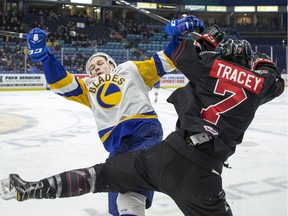 Saskatoon Blades forward Riley McKay checks Moose Jaw Warriors forward Brayden Tracey during first-period WHL action Wednesday at SaskTel Centre in Saskatoon.