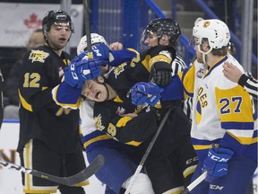Brandon Wheat Kings' Zach Wytinck (center) gets head-locked by a member of the Saskatoon Blades during a WHL game at SaskTel Centre in Saskatoon on Sunday, February 10, 2019.