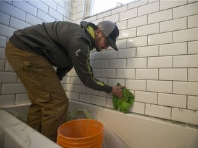 Chris Watt, owner of Array Design and Contracting, cleans tile in a bathroom he and his team are renovating in Saskatoon, SK on Wednesday, February 13, 2019.