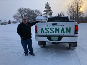 David Assman of Melville, Sask. poses alongside his truck, which bears an enormous license plate decal bearing his name.