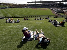 Fans watch the fifth inning of a spring baseball game between the Arizona Diamondbacks and the Oakland Athletics in Scottsdale, Ariz., Monday, Feb. 25, 2019.