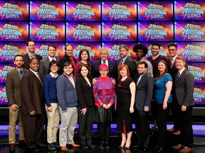 This image released by Jeopardy Productions, Inc. shows, front row from left, Brad Rutter, Colby Burnett, Alan Lin, Seth Wilson, Larissa Kelly, Monica Thieu, Pam Mueller, Matt Jackson, Jennifer Giles and Ken Jennings, back row from left, Ben Ingram, Roger Craig, David Madden, Julia Collins, host Alex Trebek, Austin Rogers, Leonard Cooper, Alex Jacob and Buzzy Cohen on the set of the game show "Jeopardy!"