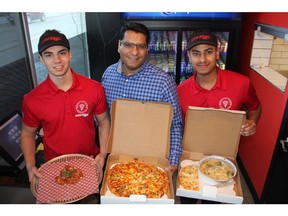 Wow Pizza employee Brycen Persaud, left, alongside co-owners Sanjay Joshi and Gurwindeh Singh with some freshly made pizzas and their special Butter Chicken wings at the College Drive restaurant on Jan. 28, 2019.