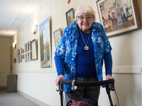 Artist Kay Parley walks beside some of her works included in the "Stones of Moffat" art exhibition at Government House on Dewdney Avenue.