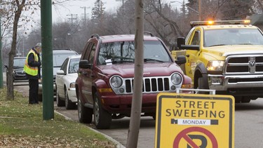 Saskatoon city council approved a 72-hour time limit for parking on residential streets on Monday, Feb. 25, 2019. In this October 2016 file photo, a towing company works with the city's parking enforcement to accommodate street sweeping operations.