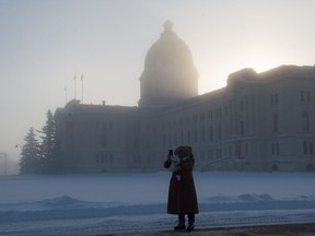 A woman takes a selfie as a cold fog hangs over the Saskatchewan Legislative Building on a frigid winter morning Friday as the mercury hung beneath -40 degrees. She said she was taking the photo to send to "those softies out West and out East." Saskatchewan residents used a record-tying amount of natural gas to stay warm during recent frigid temperatures.
