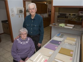 Tina and Ben Bueckert stand next to 14 files outlining the fraud that drained them of the majority of their life savings. On Jan. 31, David Matthew Adrian pleaded guilty to fraud over $5,000 and was sentenced to five years in prison. (Saskatoon StarPhoenix/Kayle Neis)