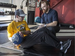 Humboldt Broncos bus crash survivor Layne Matechuk, left, works with physiotherapist John Fouhse at Zone Physio in Saskatoon, SK on Friday, March 8, 2019.