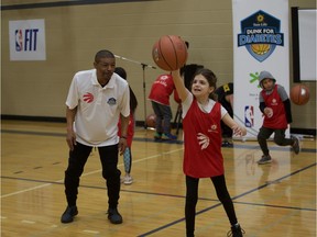 Former NBA player Muggsy Bogues teaches a few tricks to Gianna Ammazzini at the Shaw Centre on March 16, 2019, during the Sun Life Financial Dunk for Diabetes celebration event.