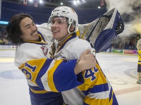 Saskatoon Blades back up goalie Dorrin Luding celebrates with forward Chase Wouters after he scored the game winning goal against the Moose Jaw Warriors during overtime of WHL playoff action at SaskTel Centre in Saskatoon on Friday, March 22, 2019.